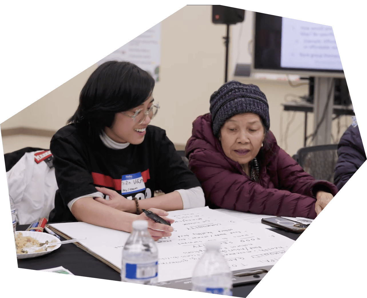 Volunteer helping woman with community worksheet
